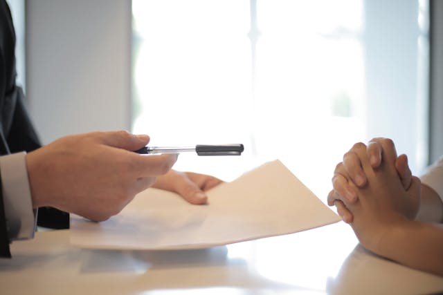 person-offering-papers-to-sign