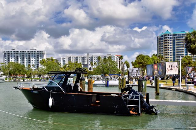 boat docked at a marina with residential buildings in the background
