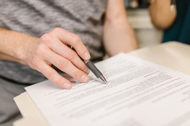 a persons hand signing a document