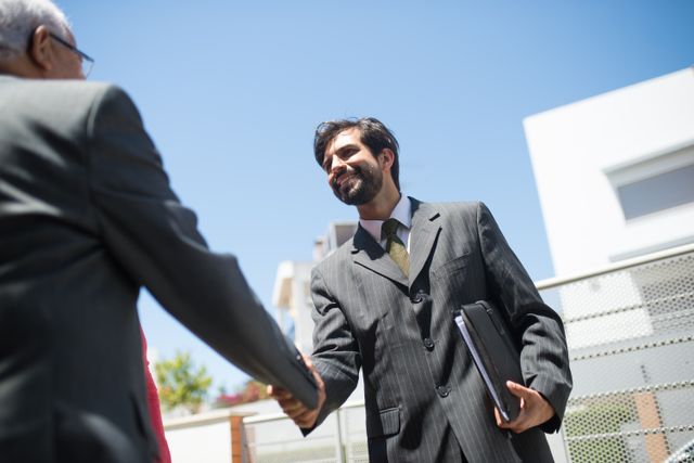 two people outside shaking hands